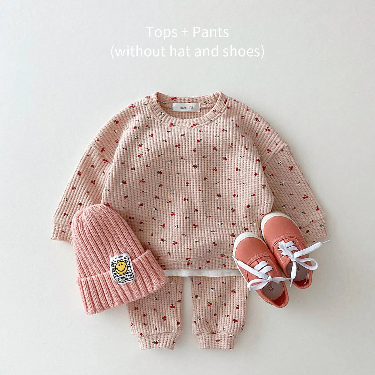 Toddler girl laughing while wearing a cute multi-print cotton clothes set, great for autumn playwear.