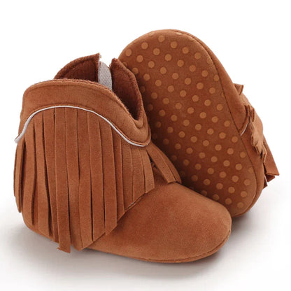 Close-up of girls' tan fringe cowboy boots, highlighting detailed stitching and soft feel.