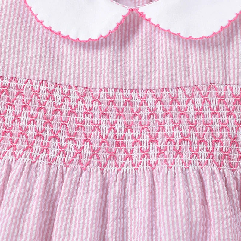 Full shot of a little girl wearing a vibrant pink rabbit print summer dress from the kids' fashion line.