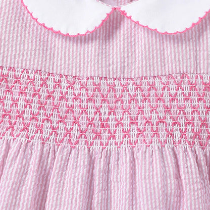Full shot of a little girl wearing a vibrant pink rabbit print summer dress from the kids' fashion line.