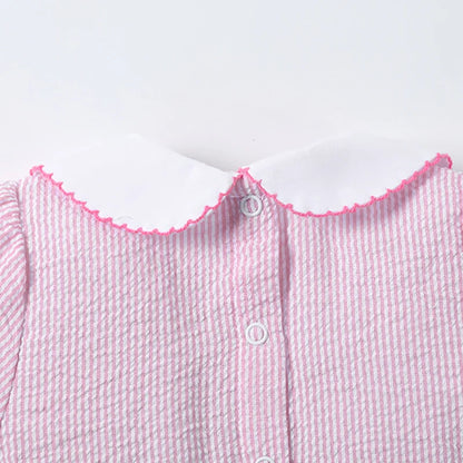 Detailed view of the soft cotton blend fabric and cute rabbit pattern on a pink girls' summer dress.