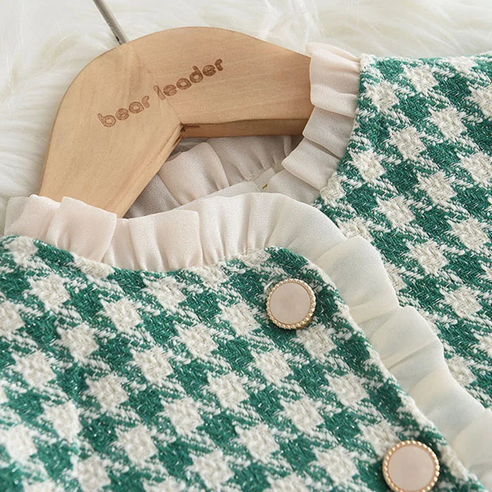Detail of the comfortable elastic waistband on girls' checkered pants from a two-piece outfit