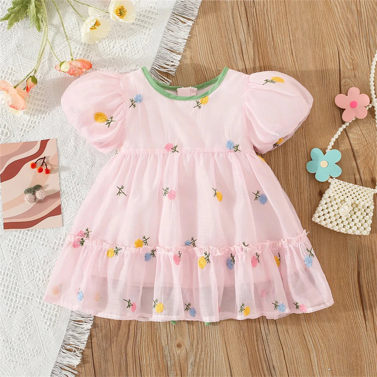 Close-up of a baby girl's summer floral dress featuring a delicate back bow design.