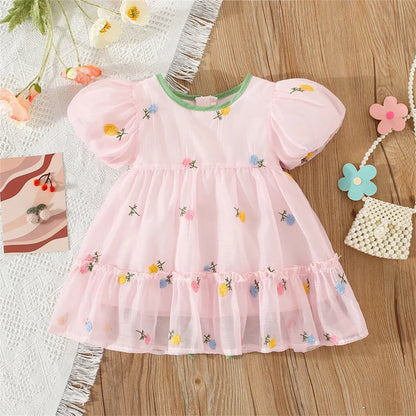 Close-up of a baby girl's summer floral dress featuring a delicate back bow design.