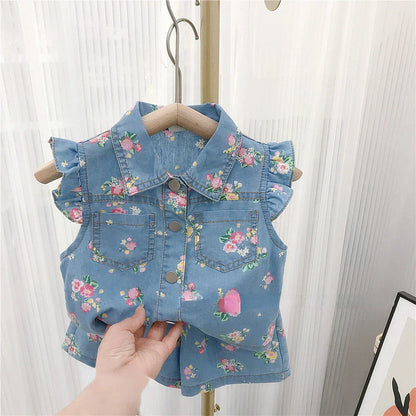 Close-up of the floral pattern on a toddler girl's summer top, with denim shorts visible