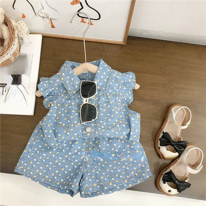 Front view of a complete toddler girl's summer outfit: floral top and blue denim shorts