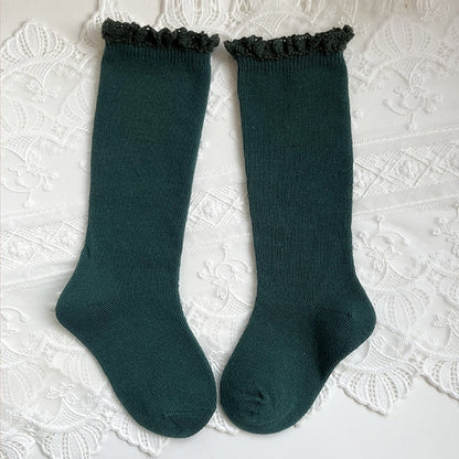 Infant accessories: white knee-high socks with large ruffle and satin bow.