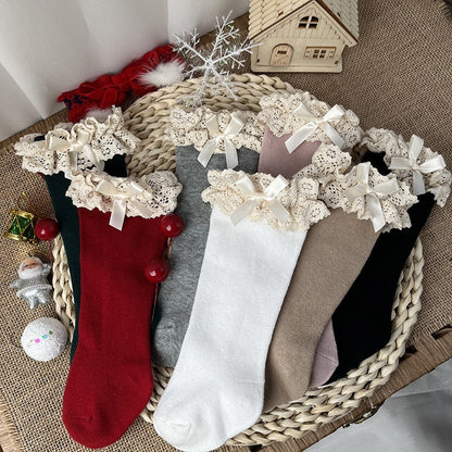 Pack of three pairs of knee-high ruffle bow socks for baby girls, various colors.
