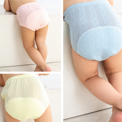 Toddler girl smiling in soft pink washable cotton potty training pants, front view, eco-friendly design.
