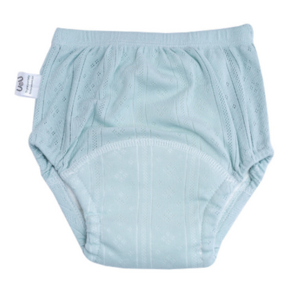 Mother helping toddler put on green washable cotton training pants, promoting independence, baby clothing.