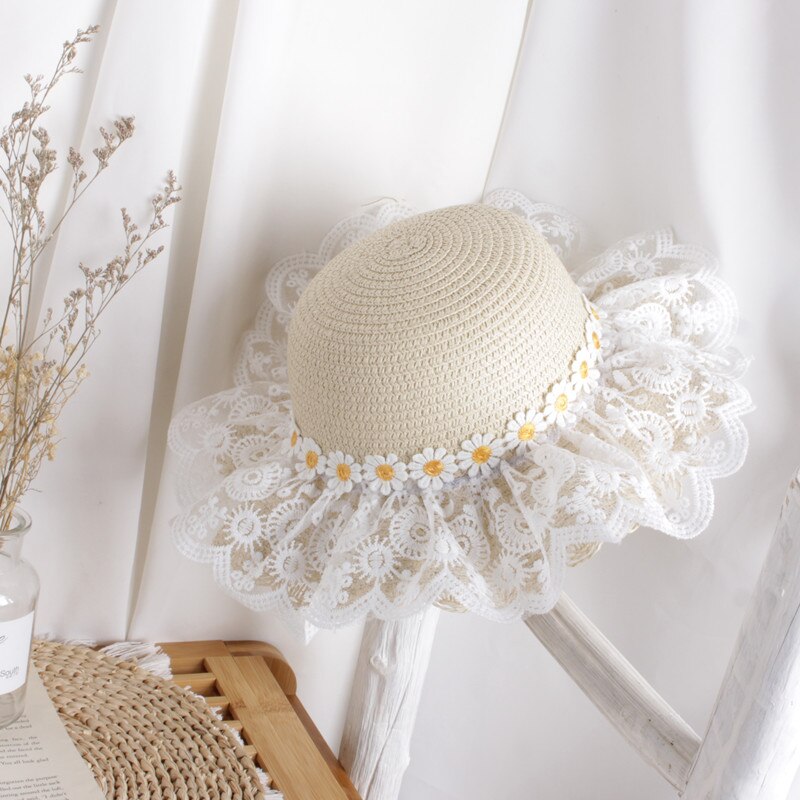 Close-up of a kids' sunflower straw hat, showcasing woven straw and bright yellow petals