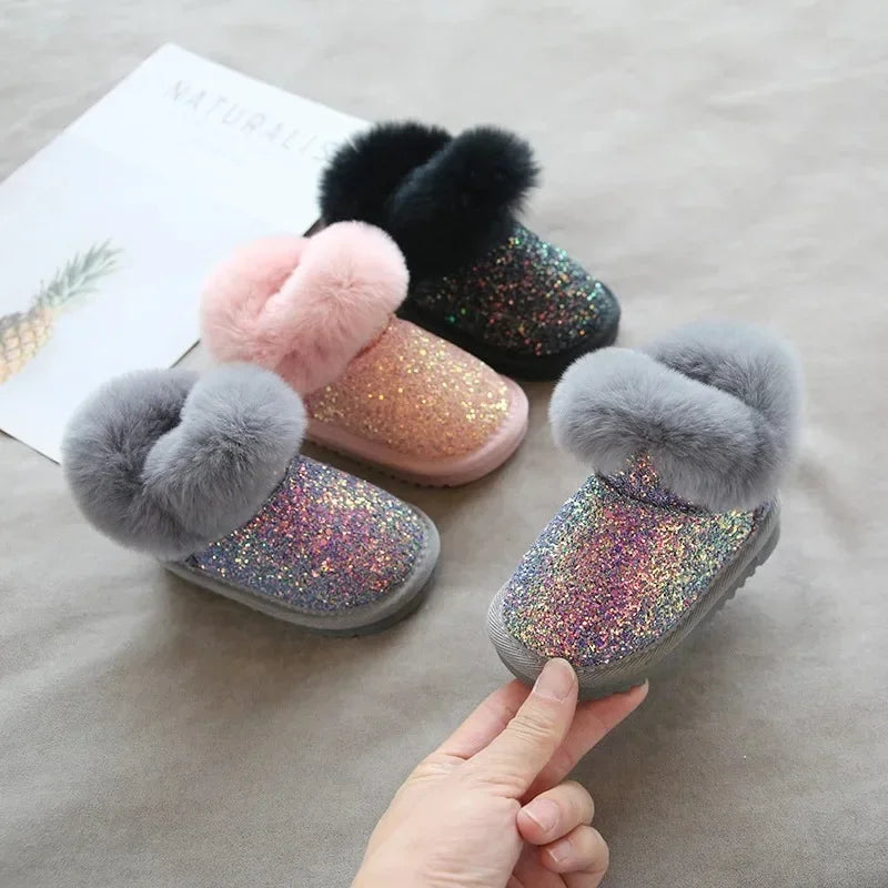 Side view of a child's glitter winter boot with a waterproof design for snowy play