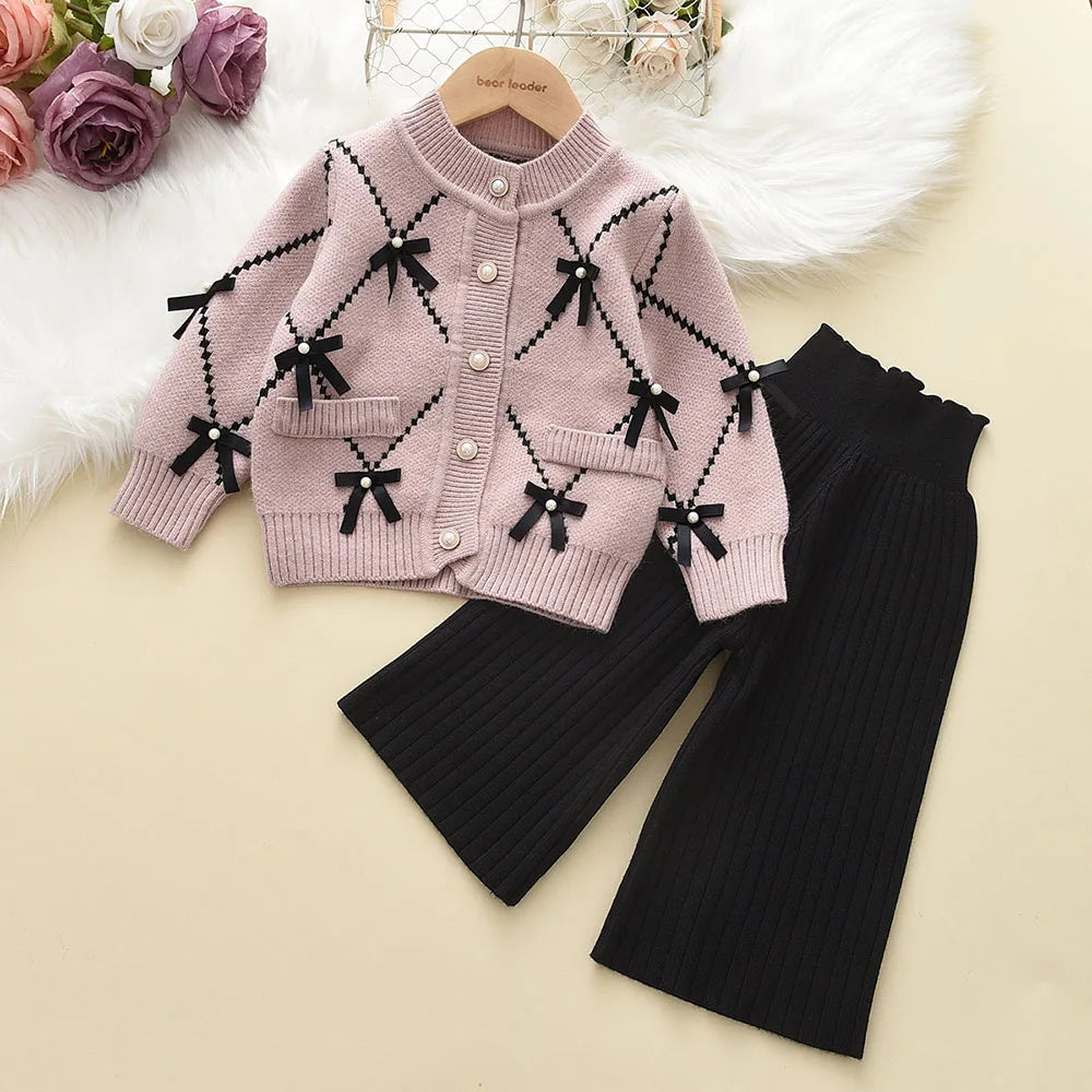 Adorable toddler girl's knitted winter outfit: sweatshirt and pull-on pants, playful print.