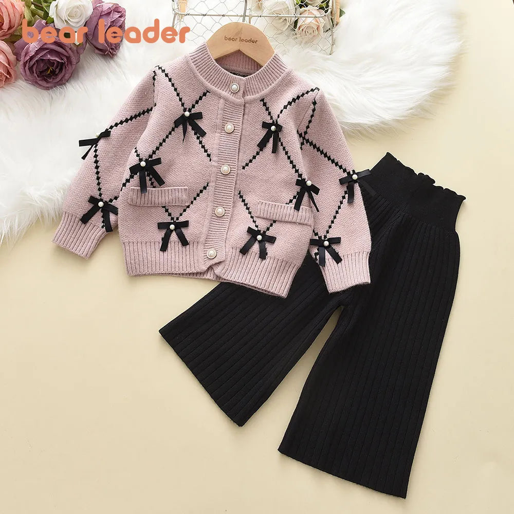 Close-up of knitted pattern on a girls' pink winter sweatshirt, soft acrylic, embroidered design.