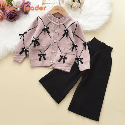 Close-up of knitted pattern on a girls' pink winter sweatshirt, soft acrylic, embroidered design.