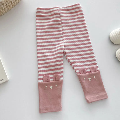 Baby in multi-colored striped cotton leggings, designed for comfort and everyday active wear.