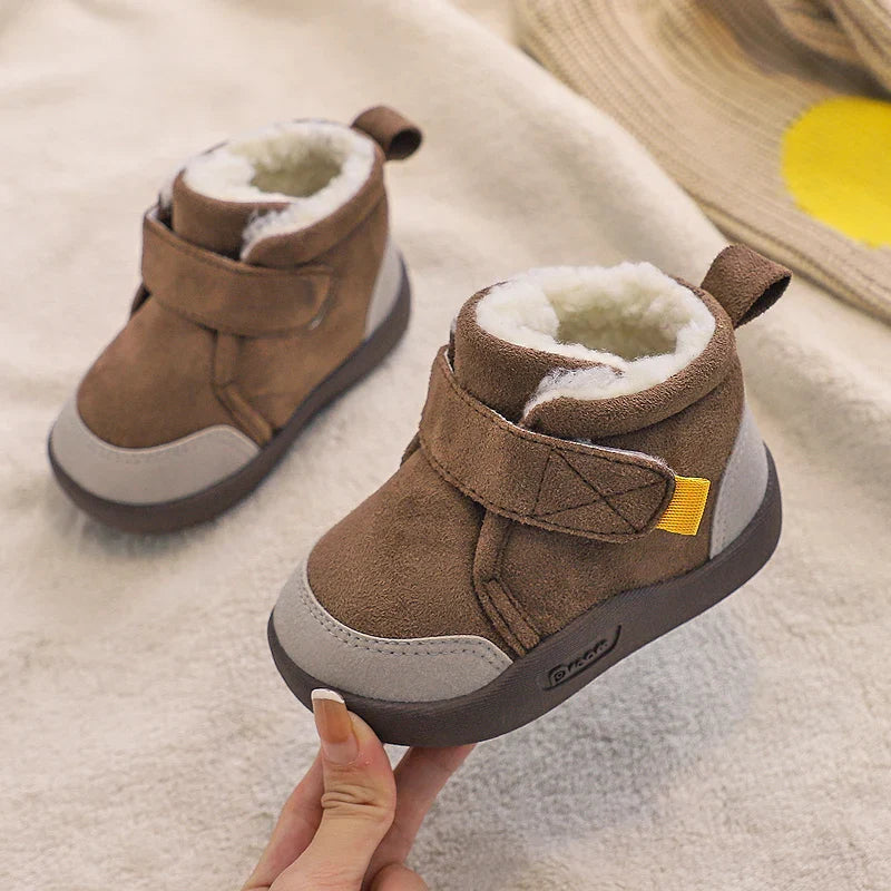 Toddler girls' warm winter boots against a snowy background, emphasizing their cold-weather utility