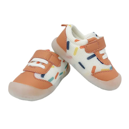 Breathable polka dot toddler trainers from a top-down angle, highlighting easy-to-use hook and loop straps for infants.