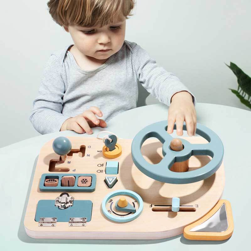 Toddler holding a wooden steering wheel toy with colorful buttons, promoting pretend play & motor skills.