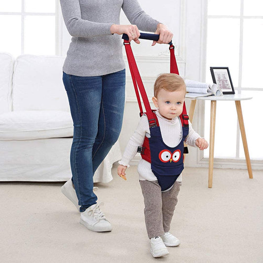 Toddler in a blue walking harness, learning to walk with parent support, a safe baby walking aid.