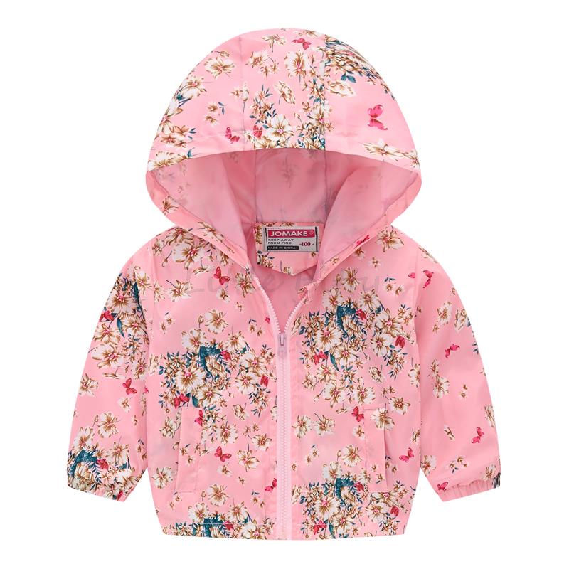 Group of diverse kids wearing floral hooded windbreaker jackets, enjoying outdoor play together.