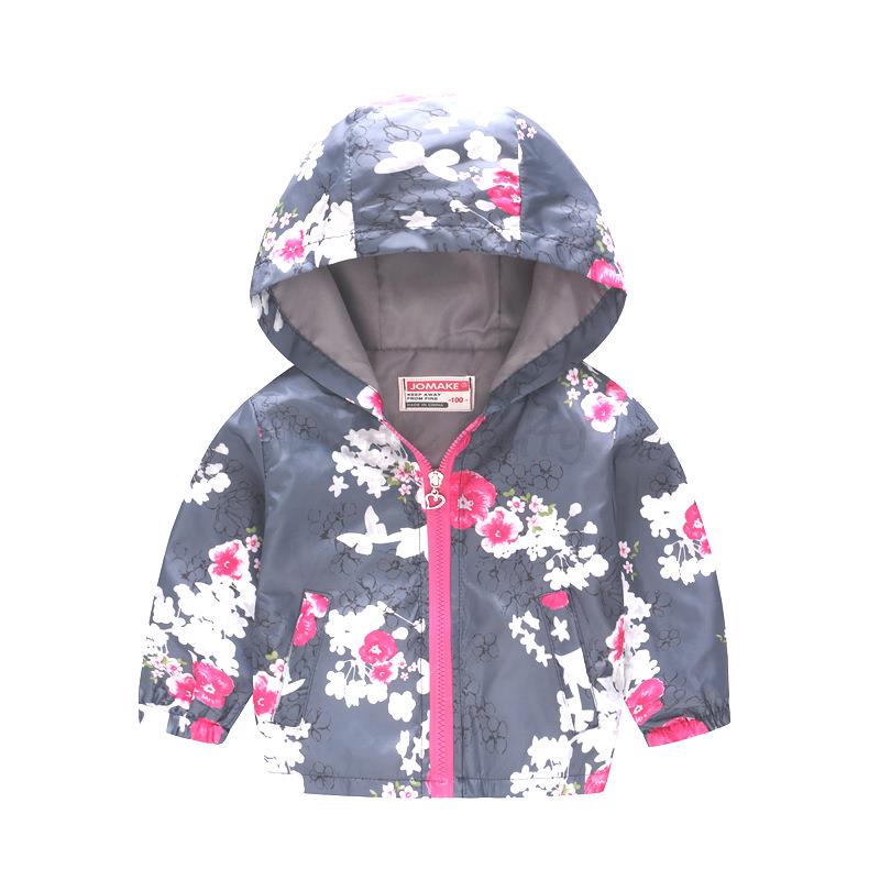 Child running in a vibrant floral polyester hooded jacket, lightweight kids' outerwear for play.