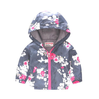 Child running in a vibrant floral polyester hooded jacket, lightweight kids' outerwear for play.