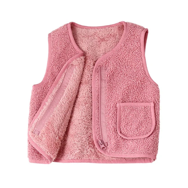 Cute toddler playing outdoors in a warm lambswool vest, showing it as practical children's winter wear.