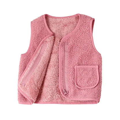 Cute toddler playing outdoors in a warm lambswool vest, showing it as practical children's winter wear.