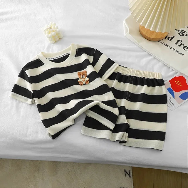 Back view of a toddler wearing a green and white striped t-shirt & shorts set, breathable cotton blend.