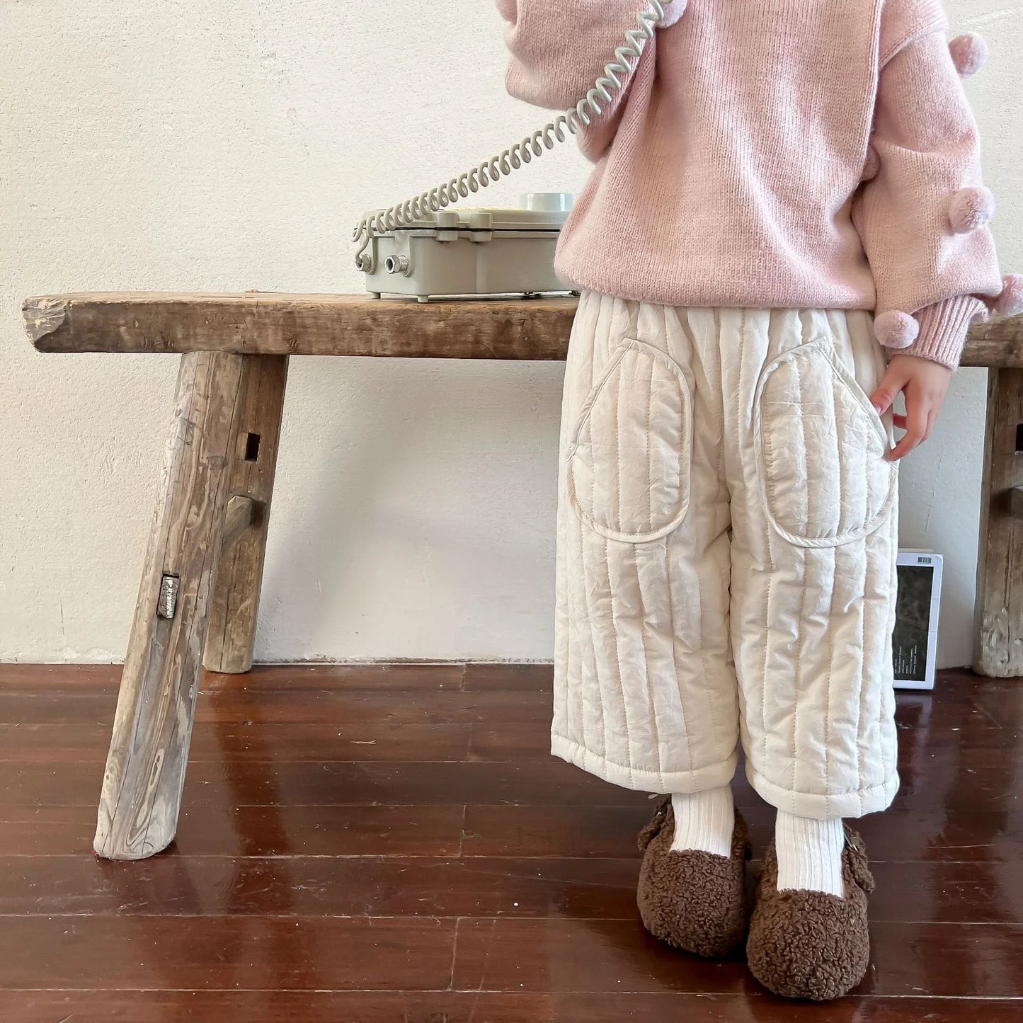 A pair of kids' elastic waist cotton harem pants folded neatly, ready for spring wear.