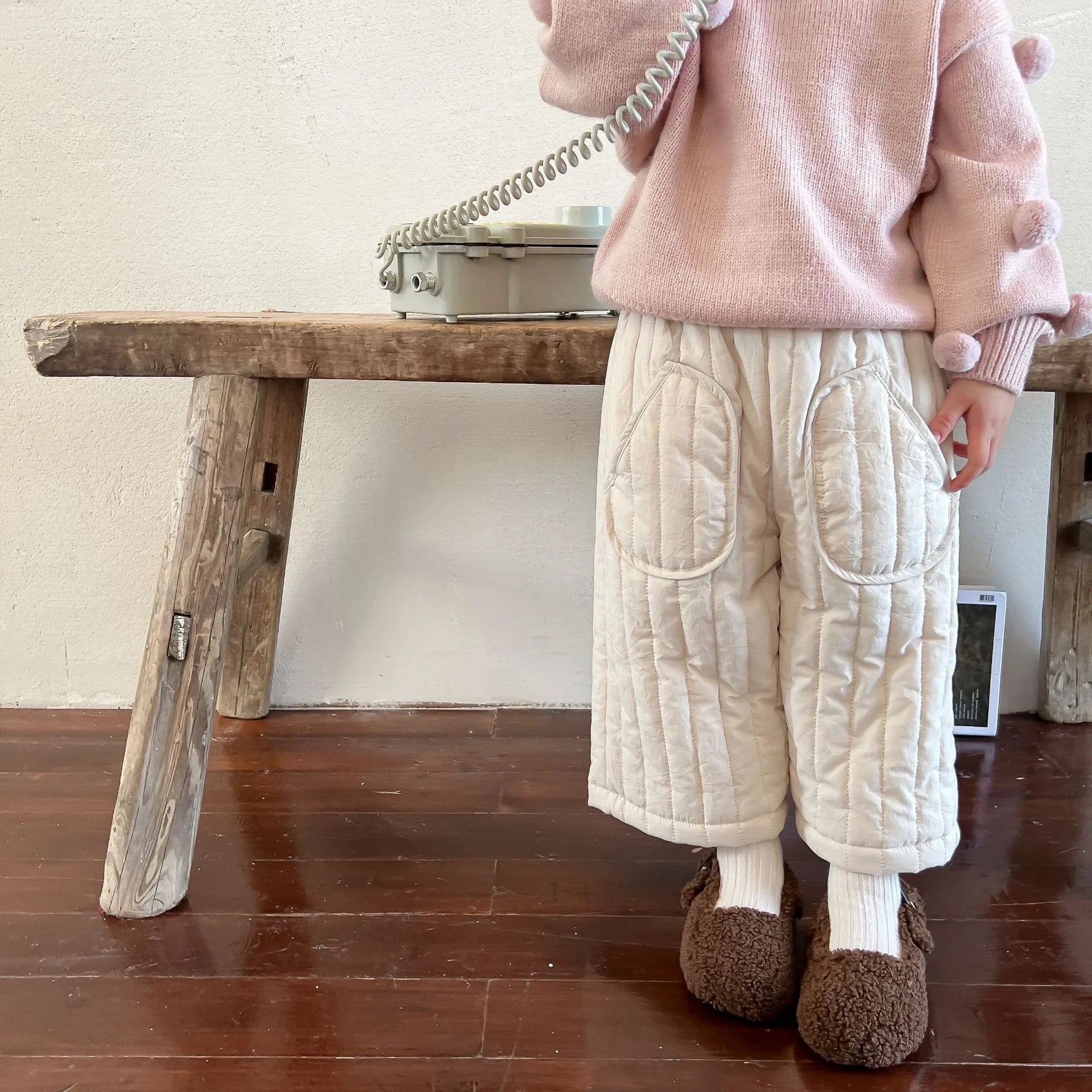 A pair of kids' elastic waist cotton harem pants folded neatly, ready for spring wear.