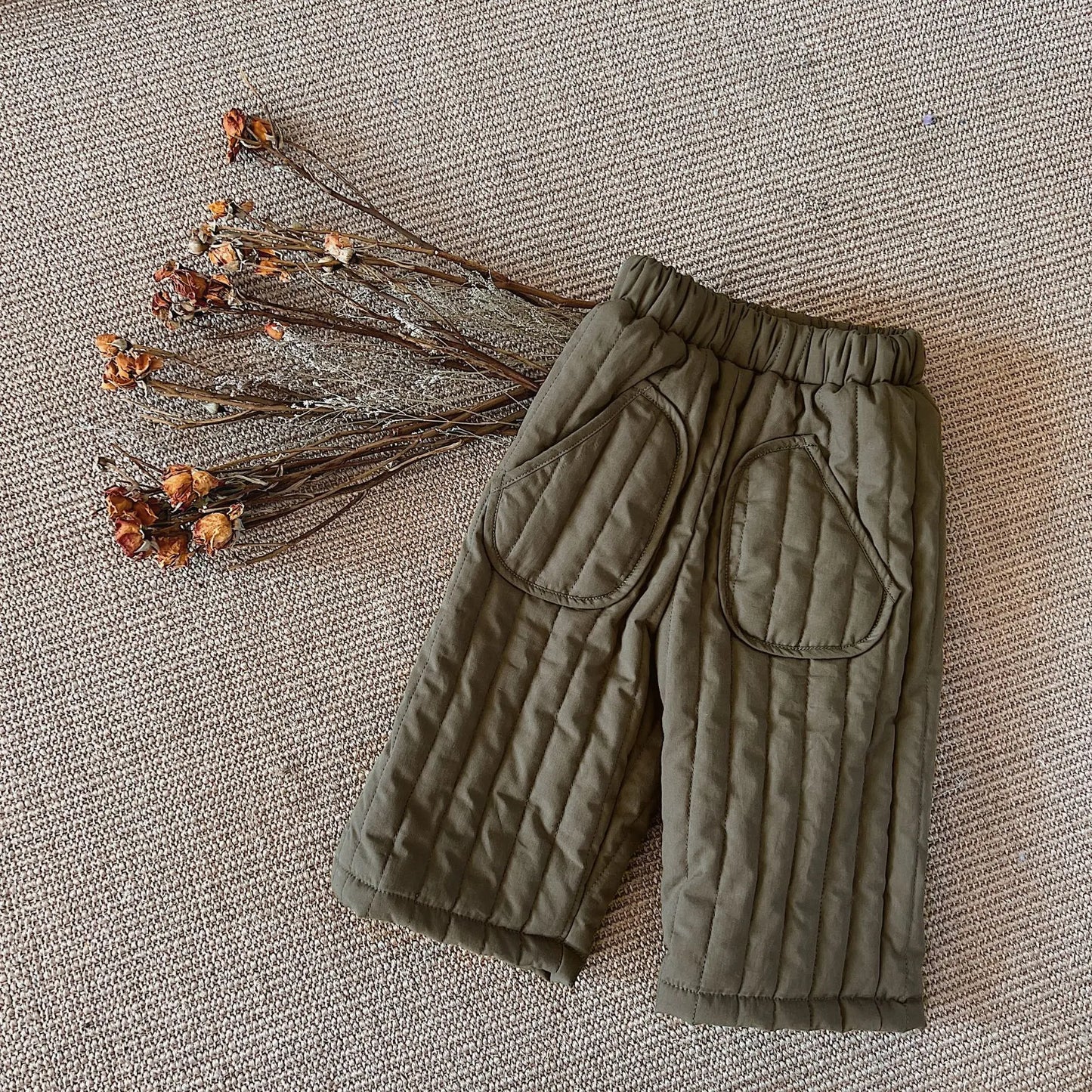 Side view of infant in loose-fitting cotton harem pants, designed for unrestricted movement.