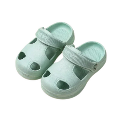 Pair of yellow breathable non-slip EVA sandals for children on a beach