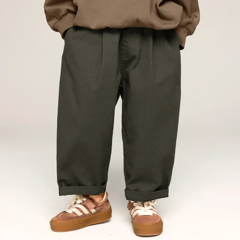 Toddler in trendy wide leg cotton pants, olive green, playing outdoors, comfortable kids clothing