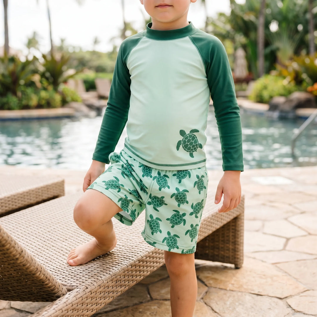Toddler long-sleeve rash guard swim set with playful tortoise print. Provides UPF 50+ sun protection for beach or pool.