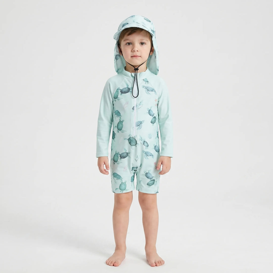Happy toddler playing in water, wearing long-sleeve sun protection swimsuit & matching swim hat.