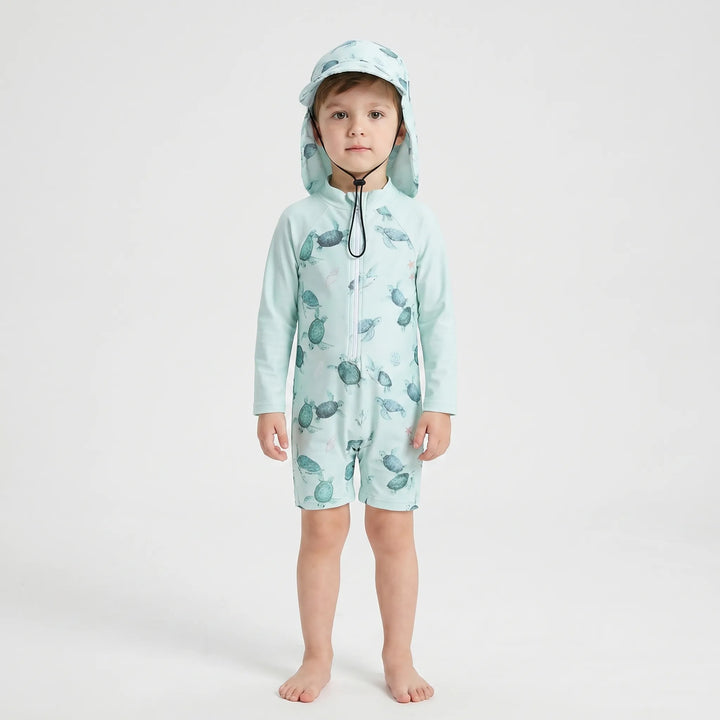 Happy toddler playing in water, wearing long-sleeve sun protection swimsuit & matching swim hat.