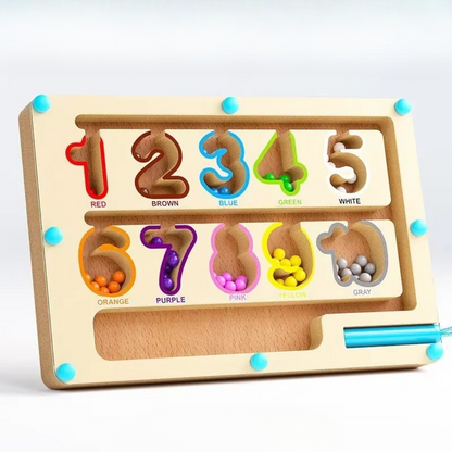 Close-up of magnetic labyrinth board game with colorful balls, depicting a child's hand guiding a pen