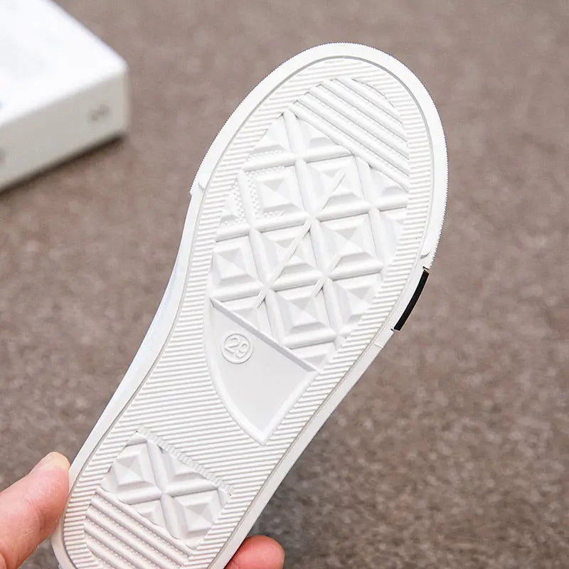 Pair of black breathable mesh children shoes with robust non-slip sole and practical velcro.