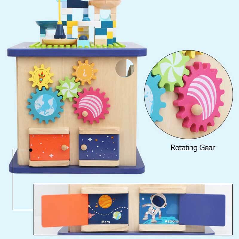 Close-up of a toddler Montessori wooden activity cube showing detailed gears and shape sorter elements.