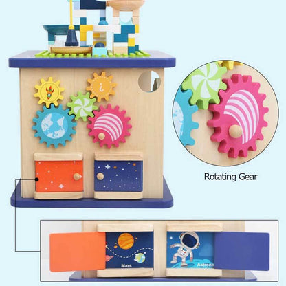 Close-up of a toddler Montessori wooden activity cube showing detailed gears and shape sorter elements.