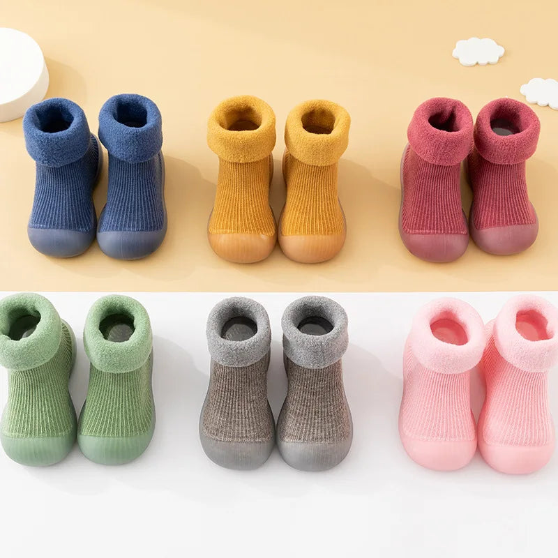 Baby wearing striped non-slip sock shoes, perfect for early walkers