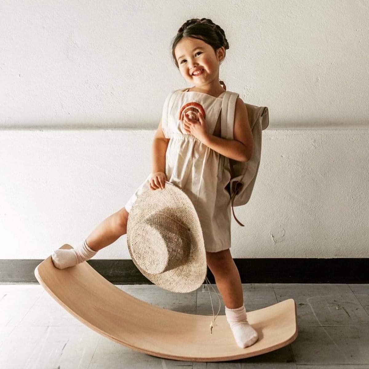Preschooler balancing on a colorful wooden active play toy, developing gross motor skills