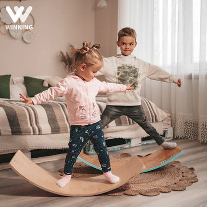 Child playing with a large wooden balance board, encouraging creativity and physical development