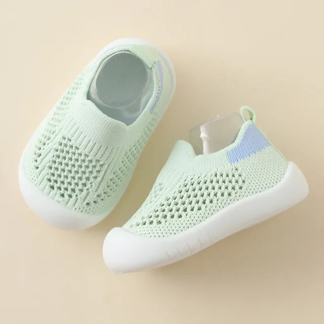 Side view of a pink soft sole toddler sneaker with strong grip