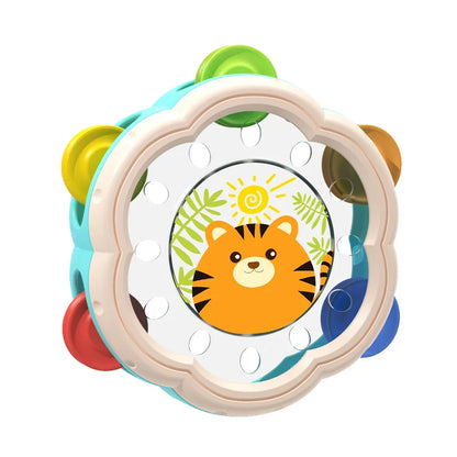 Happy toddler beating a musical hand drum, a perfect baby toy for sensory and early rhythm skill development
