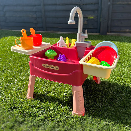 Toddler playing with interactive kitchen toy with running water, promoting pretend play and sensory development.