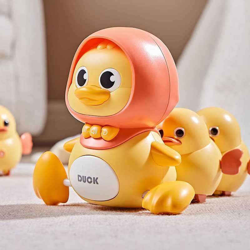 Close-up of a child's hand activating a magnetic interactive swinging duck toy for learning fun.