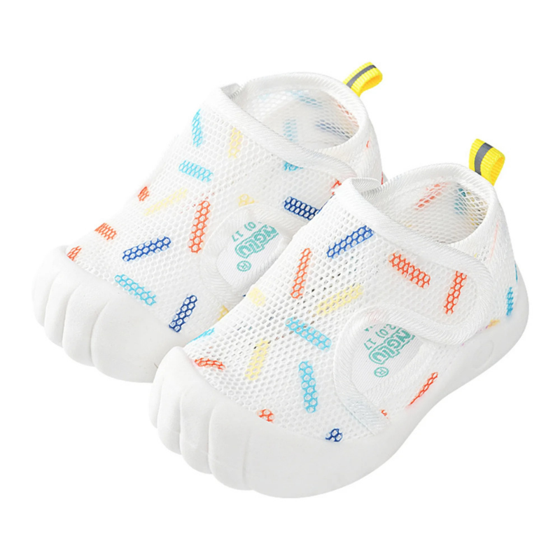 Pair of colorful quick-dry baby aqua shoes with toe guards on a sandy beach, ready for summer